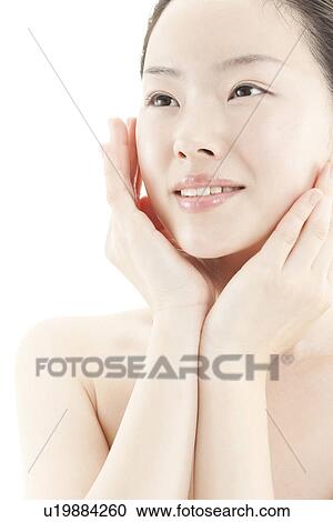 Stock Image - A young woman taking care of face skin. Fotosearch