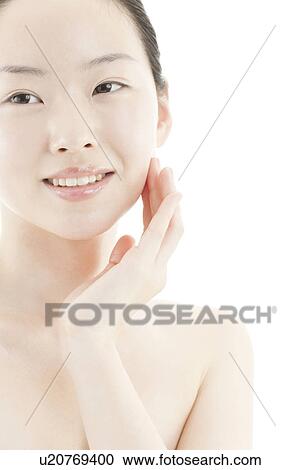 Stock Image - A young woman taking care of face skin. Fotosearch