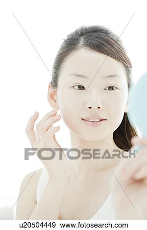 A young woman taking care of face skin View Large Photo Image Stock Photo - A young woman taking care of face skin. Fotosearch
