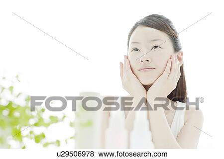 A young woman taking care of face skin View Large Photo Image Stock Photo - A young woman taking care of face skin. Fotosearch