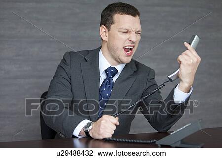 Stock Image - Angry Businessman at Desk. Fotosearch