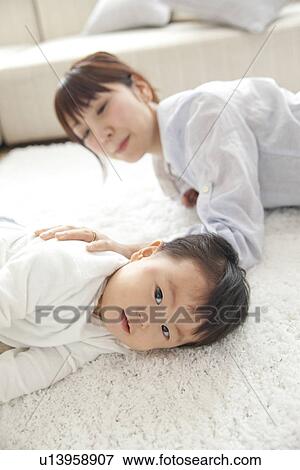 Stock Photo - Baby boy and mother in living room. Fotosearch