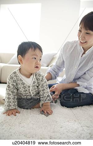 Baby boy and mother in living room View Large Photo Image Stock Photo - Baby boy and mother in living room. Fotosearch