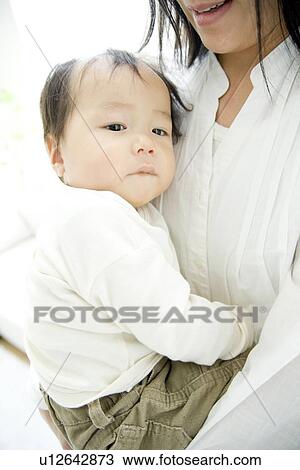 Stock Image - Baby hugging mother. Fotosearch
