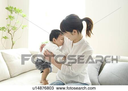 Stock Image - Baby hugging mother. Fotosearch