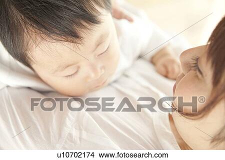Baby sleeping in mother's arms View Large Photo Image Picture - Baby sleeping in mother's arms. Fotosearch
