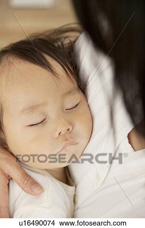 Baby sleeping in mother's arms View Large Photo Image Picture - Baby sleeping in mother's arms. Fotosearch