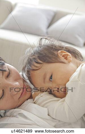 Stock Photo - Baby son sleeping on mother's chest. Fotosearch