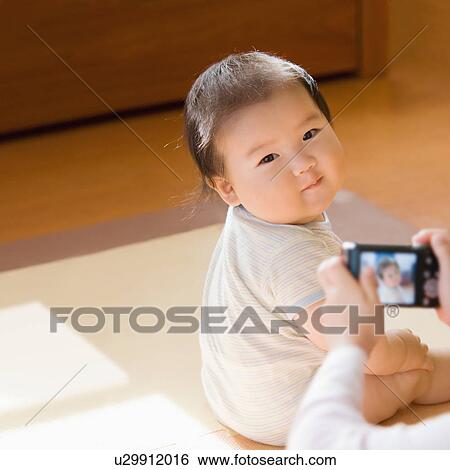 Baby's photograph taken by mother View Large Photo Image Stock Photograph - Baby's photograph taken by mother. Fotosearch