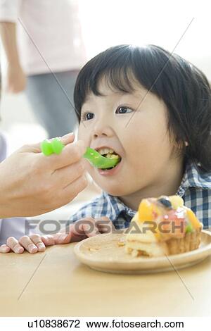 Stock Image - Boy eating cake. Fotosearch