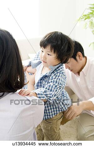 Boy getting dressed with parents View Large Photo Image Stock Photography - Boy getting dressed with parents. Fotosearch
