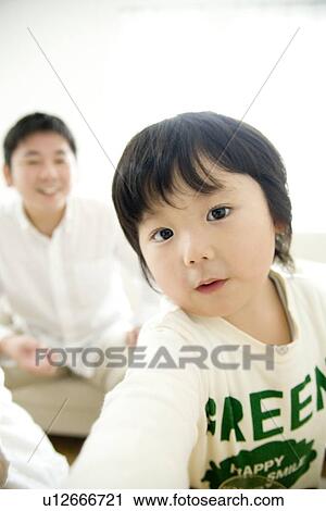 Boy looking at camera, father in background View Large Photo Image Stock Image - Boy looking at camera, father in background. Fotosearch