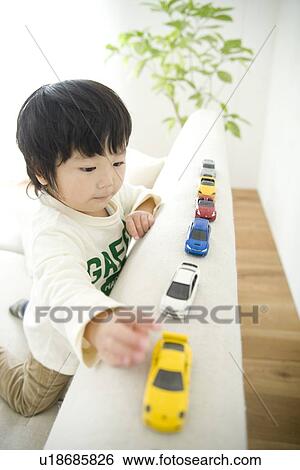 Stock Photograph - Boy playing with toy cars. Fotosearch