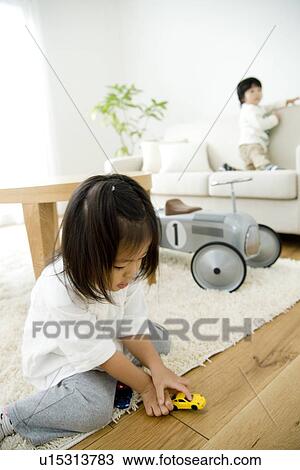 Stock Image - Brother and sister playing in living room. Fotosearch
