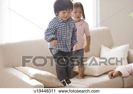 Brother and sister playing in living room View Large Photo Image Stock Image - Brother and sister playing in living room. Fotosearch
