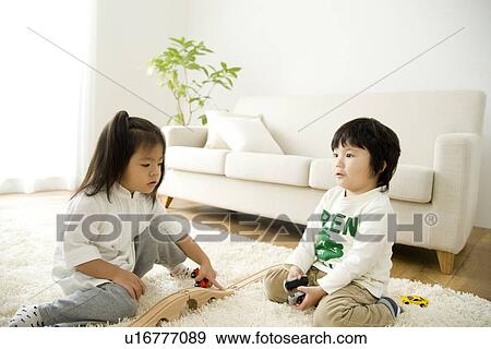 Brother and sister playing in living room View Large Photo Image Stock Photo - Brother and sister playing in living room. Fotosearch