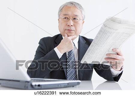 Stock Image - Businessman at Desk With Laptop and Paper. Fotosearch