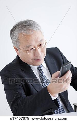 Stock Photo - Businessman Looking at Smart Phone. Fotosearch