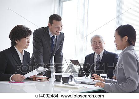 Businessmen and Businesswomen In a Meeting View Large Photo Image Picture - Businessmen and Businesswomen In a Meeting. Fotosearch