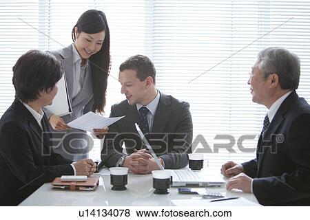 Stock Photo - Businessmen and Businesswomen In a Meeting. Fotosearch