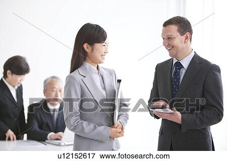 Stock Photo - Businessmen and Women In a Meeting. Fotosearch