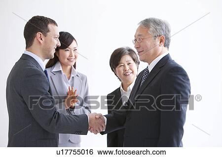 Stock Photograph - Businessmen and Women In a Meeting. Fotosearch