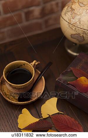 Stock Image - Coffee Cup and Autumnal Leaves. Fotosearch