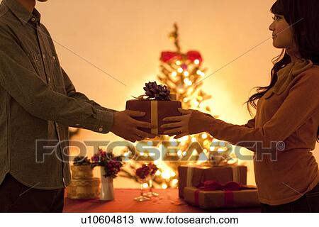 Couple Giving Christmas Presents View Large Photo Image Stock Image - Couple Giving Christmas Presents. Fotosearch