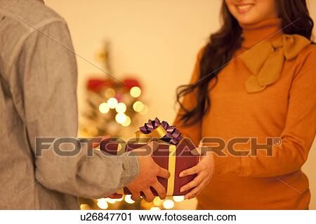 Stock Image - Couple Giving Christmas Presents. Fotosearch