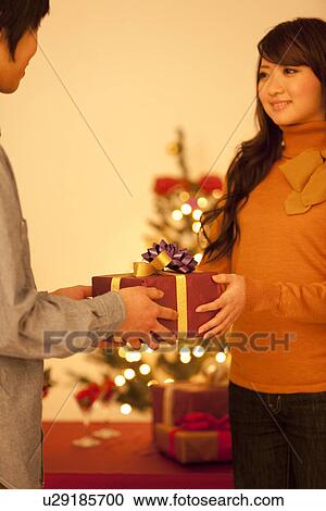 Couple Giving Christmas Presents View Large Photo Image Stock Image - Couple Giving Christmas Presents. Fotosearch