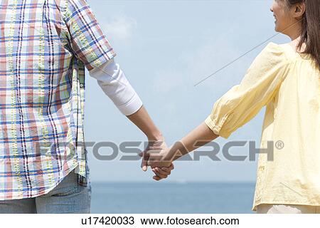 Stock Image - Couple Holding Hands. Fotosearch