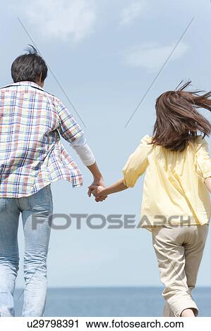 Stock Image - Couple Holding Hands. Fotosearch