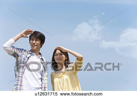 Stock Photography - Couple Shielding Eyes. Fotosearch