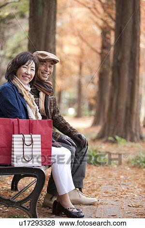 Couple Sitting on a Bench View Large Photo Image Stock Photo - Couple Sitting on a Bench. Fotosearch