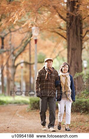 Stock Photo - Couple Walking In Park In Autumn. Fotosearch