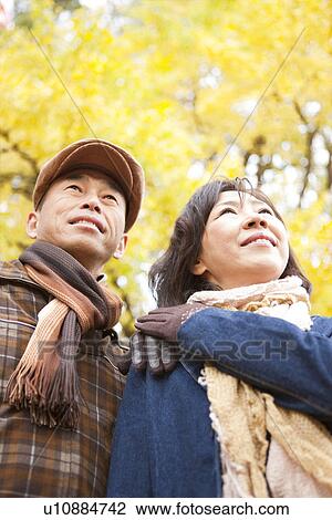 Stock Image - Couple Walking In the Woods In Autumn. Fotosearch