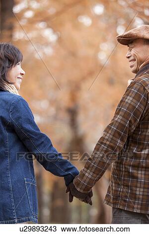 Stock Image - Couple Walking In the Woods In Autumn. Fotosearch