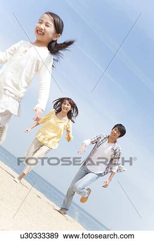 Stock Photo - Daughter and Parents Running on Beach, Tilt. Fotosearch