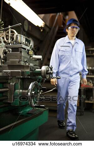 Picture - Factory Worker By Machinery. Fotosearch
