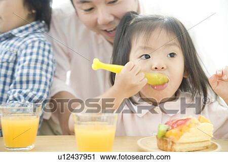 Family eating cake in living room View Large Photo Image Stock Image - Family eating cake in living room. Fotosearch