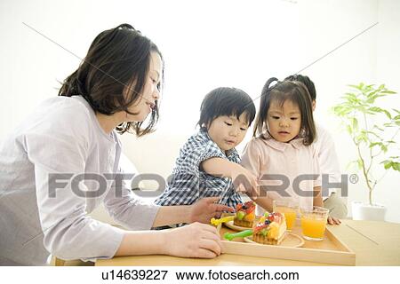 Family eating cake in living room View Large Photo Image Stock Photo - Family eating cake in living room. Fotosearch