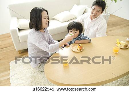 Family eating cake in living room View Large Photo Image Stock Photography - Family eating cake in living room. Fotosearch