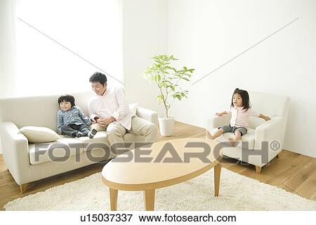 Family in living room View Large Photo Image Stock Photo - Family in living room. Fotosearch