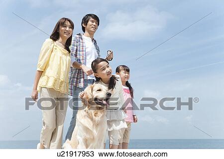 Stock Image - Family of Four and Dog on Beach. Fotosearch