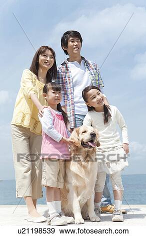 Stock Photo - Family of Four and Dog on Beach. Fotosearch