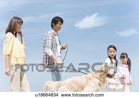 Picture - Family of Four and Dog Walking on Beach. Fotosearch