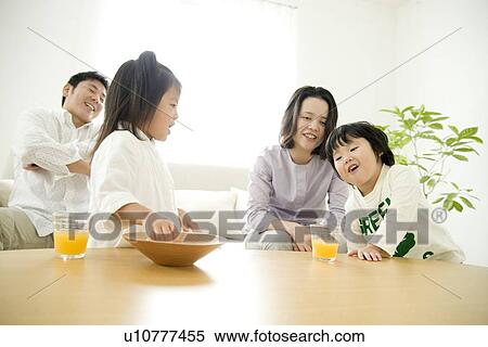 Stock Photography - Family of four in living room. Fotosearch