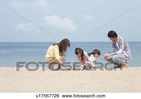 Stock Photograph - Family of Four Playing on Beach. Fotosearch
