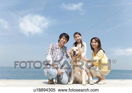 Stock Photography - Family of Three and Dog on Beach. Fotosearch