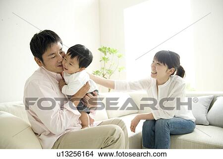 Family of three in living room View Large Photo Image Picture - Family of three in living room. Fotosearch